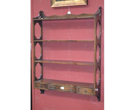 A Bevan Funnell mahogany four tier wall shelf, serpentine shelving, one long drawer flanked by short to base.