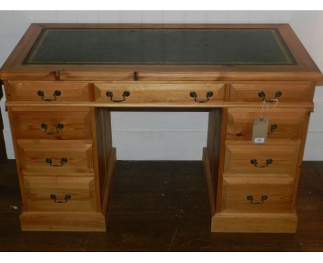 A 20th century pine pedestal desk, having green leather skiver, and an arrangement of nine drawers. 
