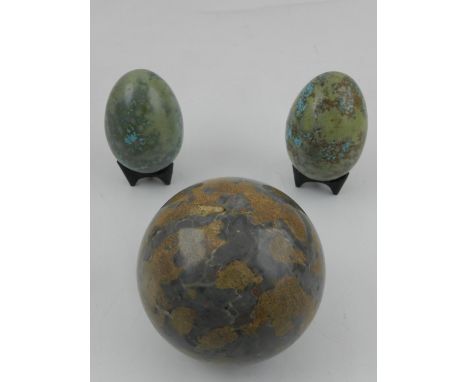 A 20th century marble ball, together with two ceramic eggs. 