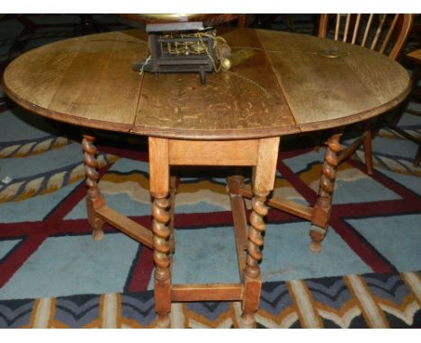 An early 20th century oak gate-leg table with barley twist legs, together with four wheel and stick back dining chairs, and t