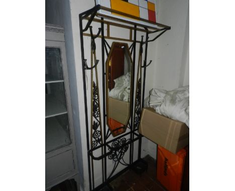 A 20th century wrought steel hall stand, painted black and gold with a rack above mirror plate flanked by hooks and stick sta