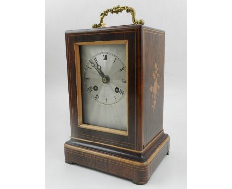 A late 19th century rosewood cased mantel clock, the case with foliate inlay with a silvered engine turned dail set out with 