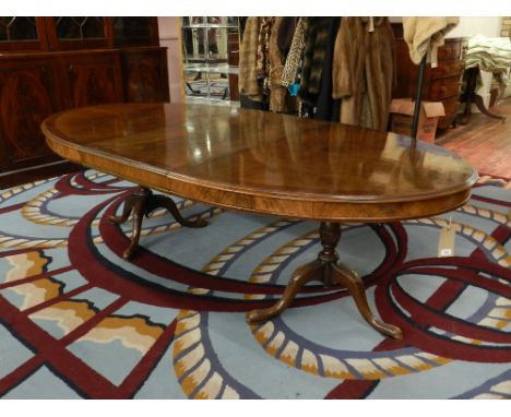 Charles Tozer, London. A Queen Anne style walnut oval dining table, raised on turned baluster shaped supports and tripod cabr