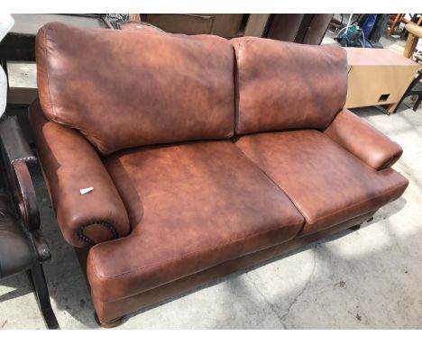 A TAN LEATHER TWO SEATER SOFA 