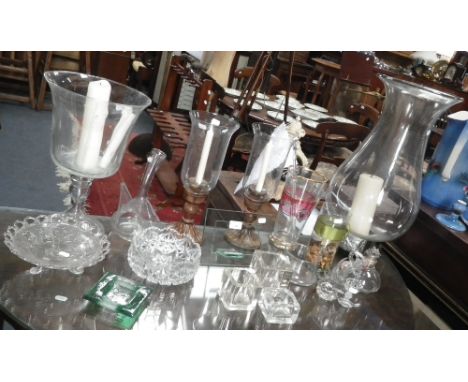A large glass storm lamp, and similar glassware