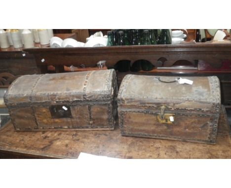 An 18th century domed top travelling trunk with leather and brass nail covering and another similar