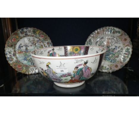 An Oriental punch bowl decorated with figures in traditional costume and two similar plates