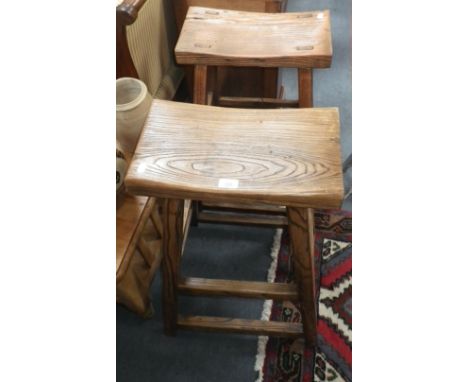 A pine stool of naïve construction, another similar and a pine book table with fitted drawers (3)