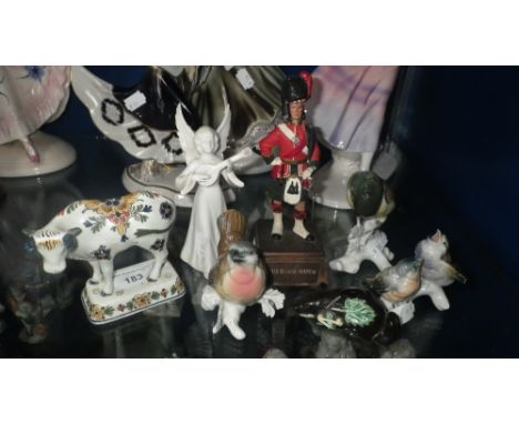 A collection of ceramic ornaments including a Delft cow