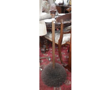 A bristled floor standing boot cleaner with a pineapple finial