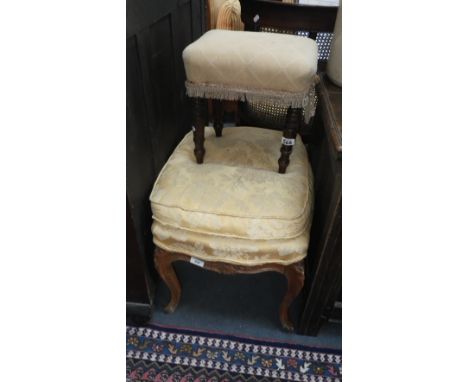 A French walnut footstool, upholstered in gold material and a similar stool