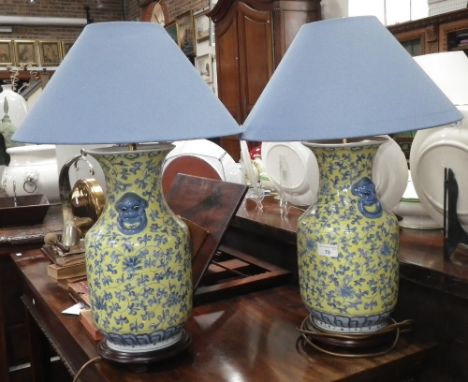 A pair of Oriental style yellow ground and blue decorated ceramic table lamps