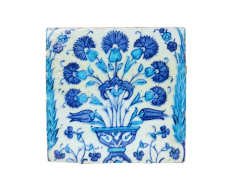 AN IZNIK POTTERY TILE WITH A FLOWER VASE Ottoman Turkey, 17th centuryOf square shape, underglaze-painted in cobalt blue and t
