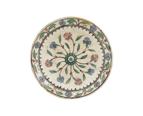 AN IZNIK POTTERY DISH WITH RED AND BLUE HYACINTHS Ottoman Turkey, 17th centuryOf shallow rounded shape, resting on a short ci