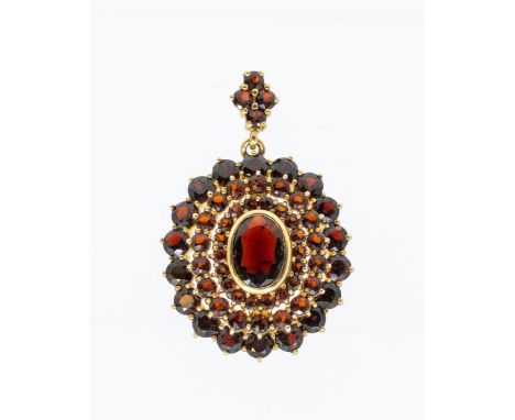A garnet set 9ct gold pendant/ brooch, comprising a an domed oval rub-overset to the centre with a oval mixed cut garnet, wit