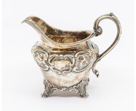 A Victorian silver ogee shaped jug, chased decorative band to upper section, on scroll feet with apron, hallmarked by John Ev