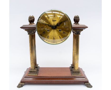 A large mid 20th century, mahogany, 8-day, Continental mantel clock by Urgos with Roman numerals, column supports and pineapp