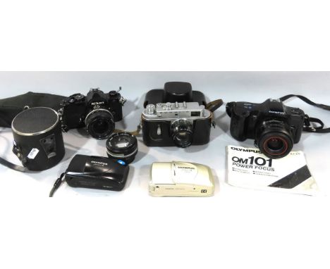 A collection of old cameras, including a Zorki-4, a Nikon, an Olympus om101, two Olympus pocket cameras, and a Nikon lens.