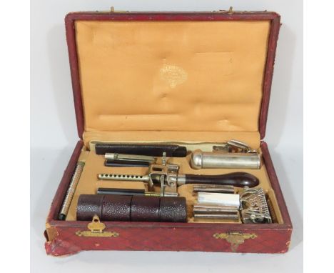 A patent Kampfe Bros. razor set with accessories all contained in distressed red padded leather box. 