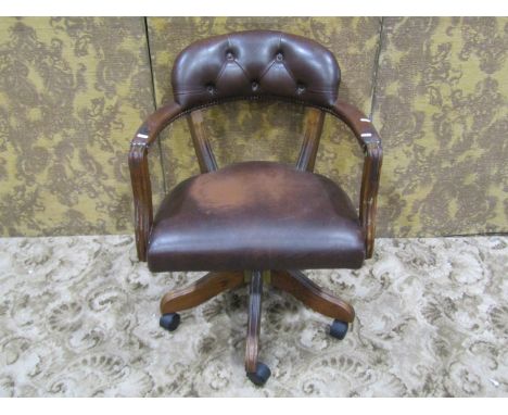 A reproduction swivel desk chair with horseshoe shaped button back 