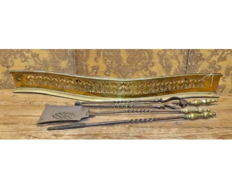 A 19th century brass serpentine fire fender with fretwork grill, together with a set of iron and brass fire irons, together w
