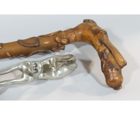 An Art Deco walking stick with a gymnastic naked female handle, and another stick with floral carved shaft and a dog with rab