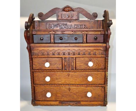 A 19th century oak apprentice chest of drawers, dated 1899 to a Mrs T Walker, with a row three frieze drawers with shelf belo