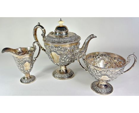 A heavily engraved three piece silver tea service, with scrolling and acanthus leaf detail, Birmingham, 1910, maker Willam De
