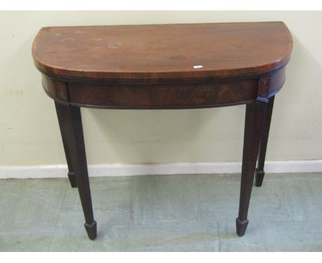 A 19th century cross banded mahogany folding card table with green felt lined top, raised on taping squared Legs and spade fe
