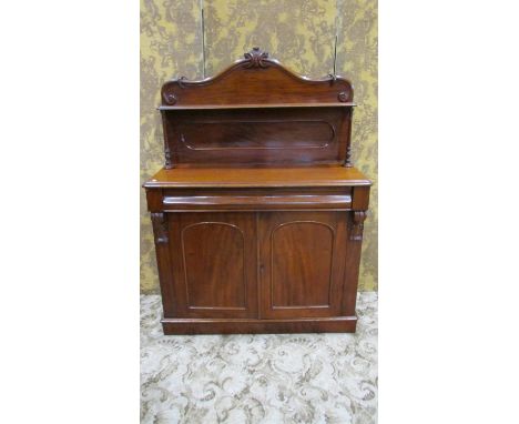 A Victorian mahogany chiffonier with raised arched and scrolled panelled back over a frieze drawer and cupboard enclosed by a