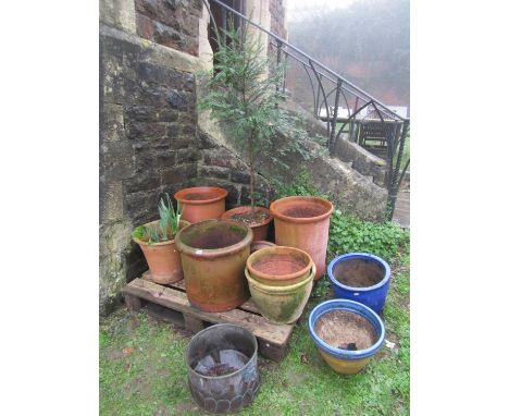 Seven weathered terracotta planters of varying size and design, two further glazed planters and a weathered copper coal bin l
