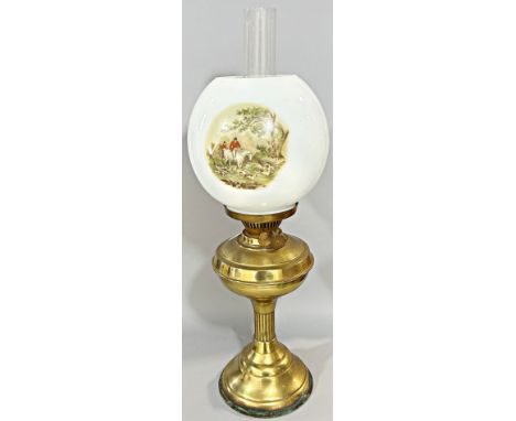A brass oil lamp with a shade decorated with fox hunting scenes. 