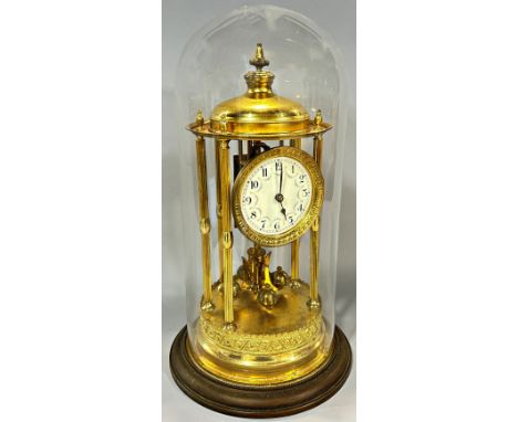 A large brass anniversary clock, beneath a large glass dome, 39cm high.