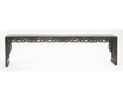 A hardwood long Bench, late 19th century, a fretwork apron of scrolling vine, peaches and melons, the pierced ends with ruyi 