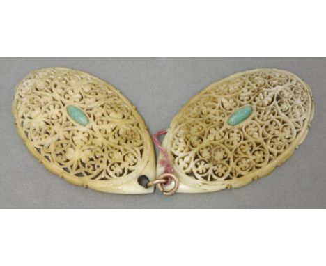 An ivory pendant, second half of the 19th century, each section finely filigree carved and set in the centre with an oval jad