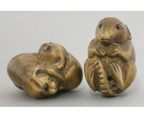 A wood Netsuke,20th century, of a crouching rat with black glass eyes, signed Gyokuseki,and another, of two playful pups, all
