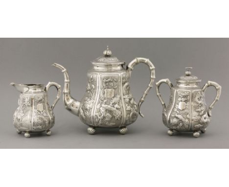 A fine three-piece silver Tea Set,c.1900, by Jian Ji, Canton and Shanghai, each with six panels of flowers including iris, ch