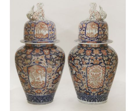 A pair of Arita baluster Vases and Covers,mid 19th century, the ovoid ribbed body typically painted in red, blue and gold wit