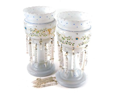 A pair of late 19thC milk glass lustres, decorated in enamel with a band of flowers, with clear prismatic glass drops, 36cm h