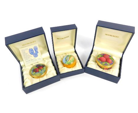 Three Moorcroft Pottery miniature enamel pill boxes, comprising one decorated in the Pomegranate pattern, 4cm wide, and a Pom