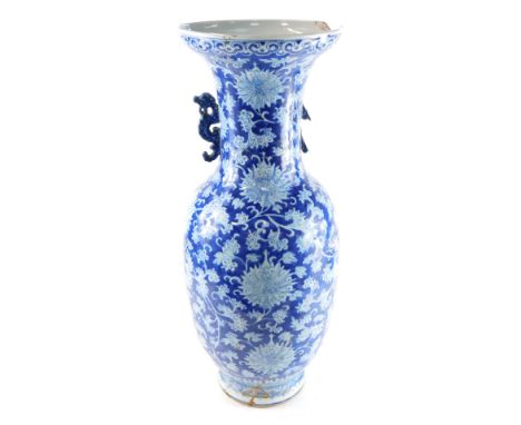 A 19thC Qing Dynasty blue and white porcelain vase, with dragon handles, decorated with flowers and scrolling leaves, against