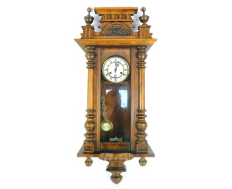 A late 19thC walnut cased Vienna wall clock, with a moulded top, Corinthian columns with white ceramic Roman numeric dial, an