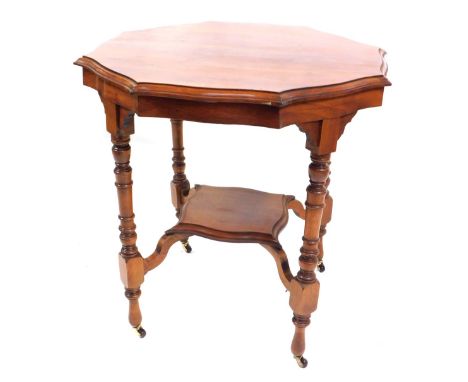 A Victorian mahogany octagonal topped window table, with fluted borders and lowered shelf, on shaped supports terminating in 