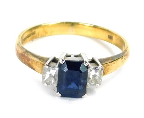 An 18ct gold sapphire and diamond dress ring, with a rectangular cut central sapphire, in a raised four claw basket setting, 