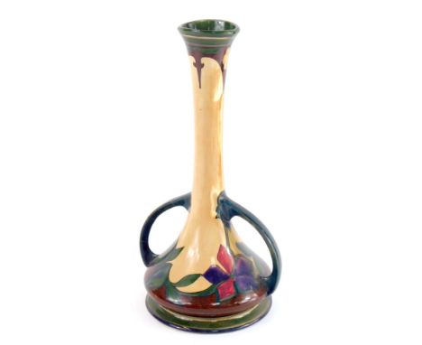 An early 20thC Art Nouveau Gouda pottery vase, of twin handled slender neck form, decorated with flowers, painted mark, 32cm 
