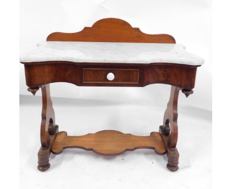 A Victorian mahogany marble top washstand, the shaped top above a single drawer, with lower shelf, on scroll supports with bu