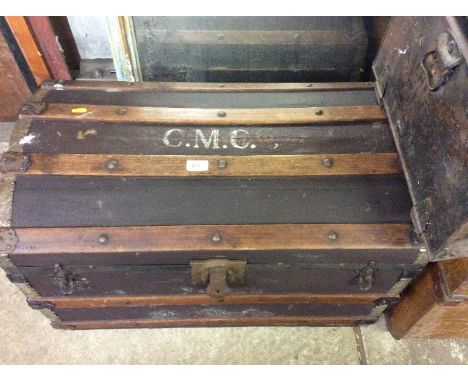 A wooden bound dome topped trunk and a tin trunk