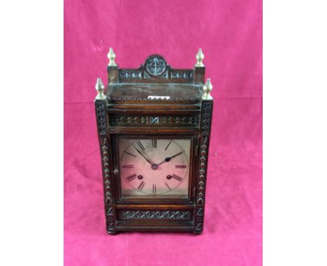 An oak cased mantel clock with silvered dial and Ting Tang movement