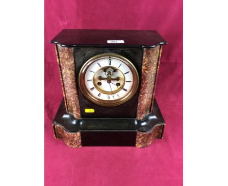 A late 19th Century French black slate two hole mantel clock with visible escapement 