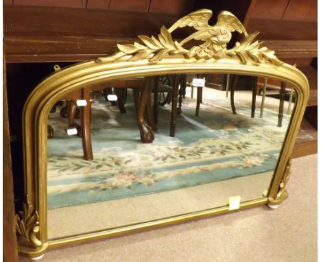 A late 19th Century gilt wood framed Overmantel Mirror, the top with eagle and swag mount, raised on ceramic ball feet, 44  w